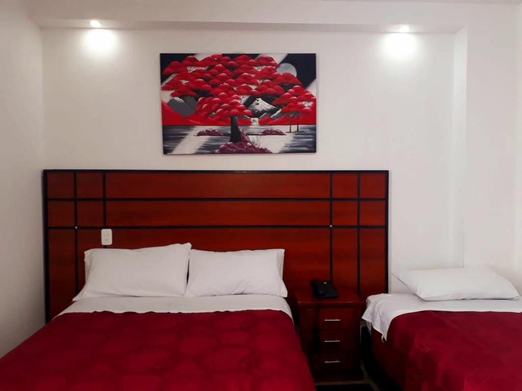 SangolquíHOTEL DEL RIVER MONUMENTO的卧室配有两张床,墙上挂着一幅画