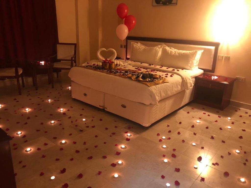 马斯喀特Farah Hotel Apartment的卧室配有一张带灯和气球的床,位于地板上