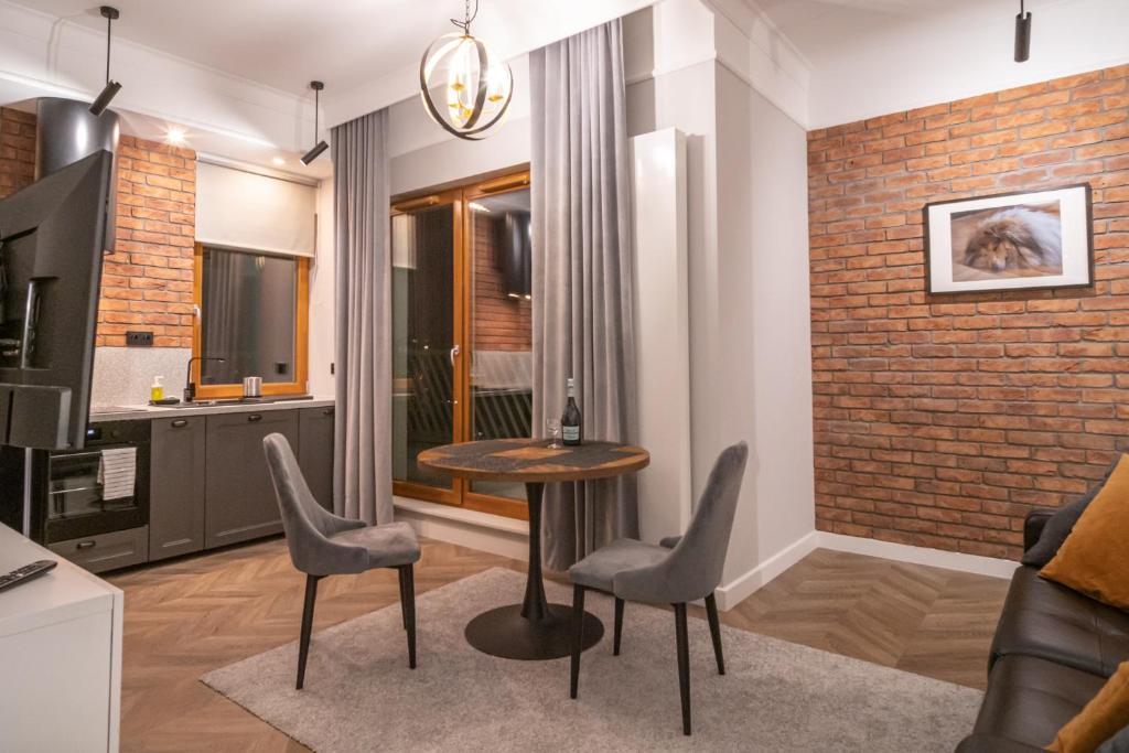 华沙Labo Apartment Metro Młociny的客厅配有桌椅和砖墙