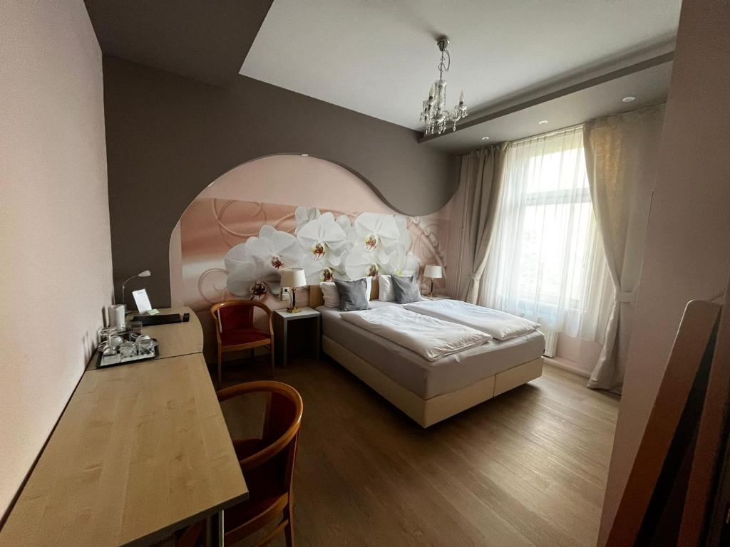 柏林欧亚瑟膳食公寓酒店的一间卧室配有一张床、一张桌子和一张桌子