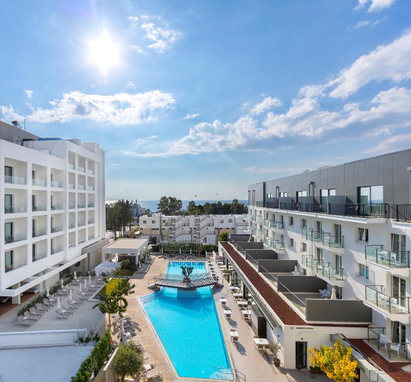 帕福斯阿内密套房公寓式酒店的一张酒店庭院的图片,里面设有一个游泳池