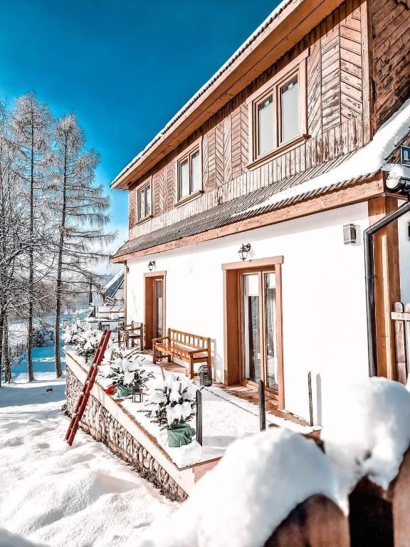 恰萨纳格拉Góralska Chata的雪中带门廊的房子