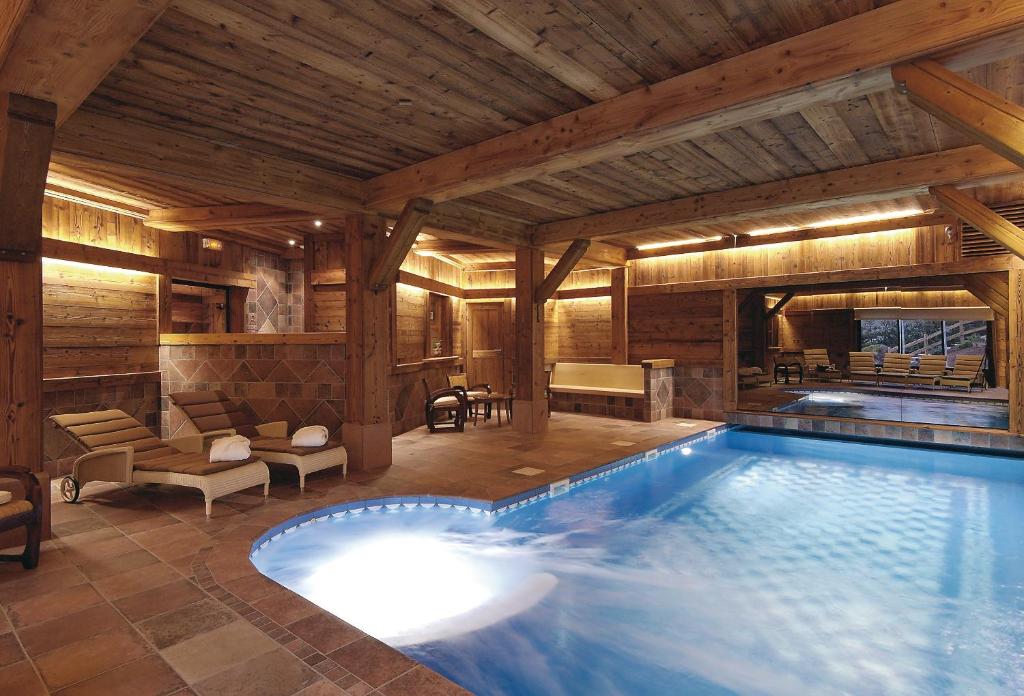 热拉梅Relais et Châteaux - Les Bas-Rupts的木屋内的大型游泳池