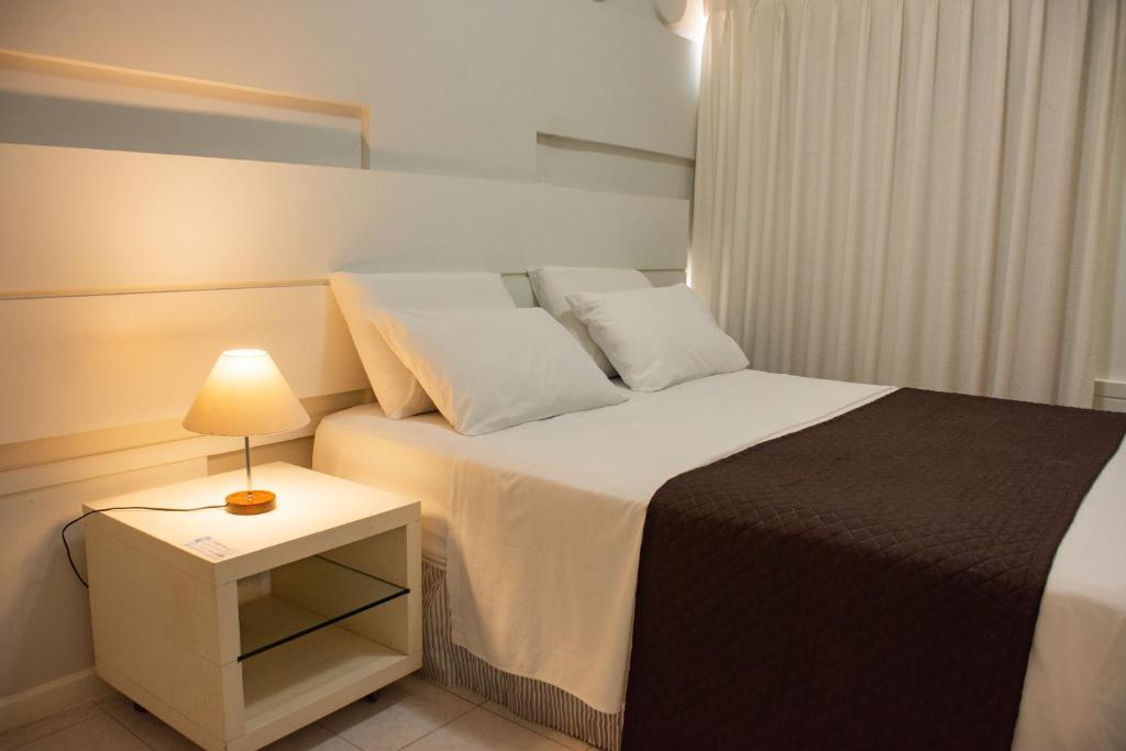 费拉迪圣安娜克拉斯公寓式酒店的一间卧室配有一张床和一个带灯的床头柜