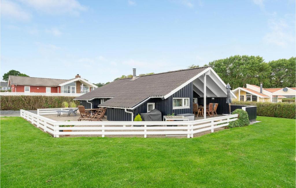 海耶斯Lovely Home In Sjlund With House Sea View的院子内有白色围栏的黑色房子