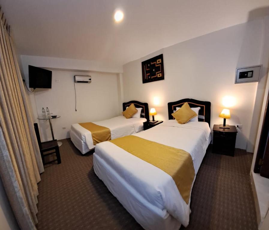 马丘比丘Real Excelencia的酒店客房设有两张床和电视。