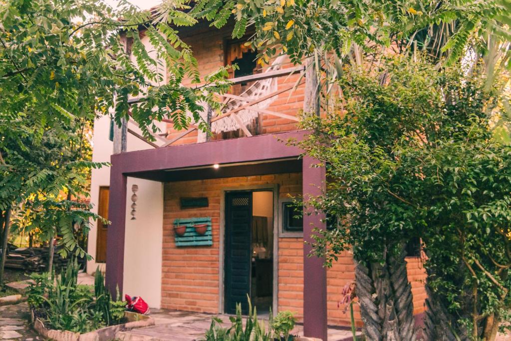 韦尔卡鲍Recanto Pitanga的一座紫色前门和树木的房子