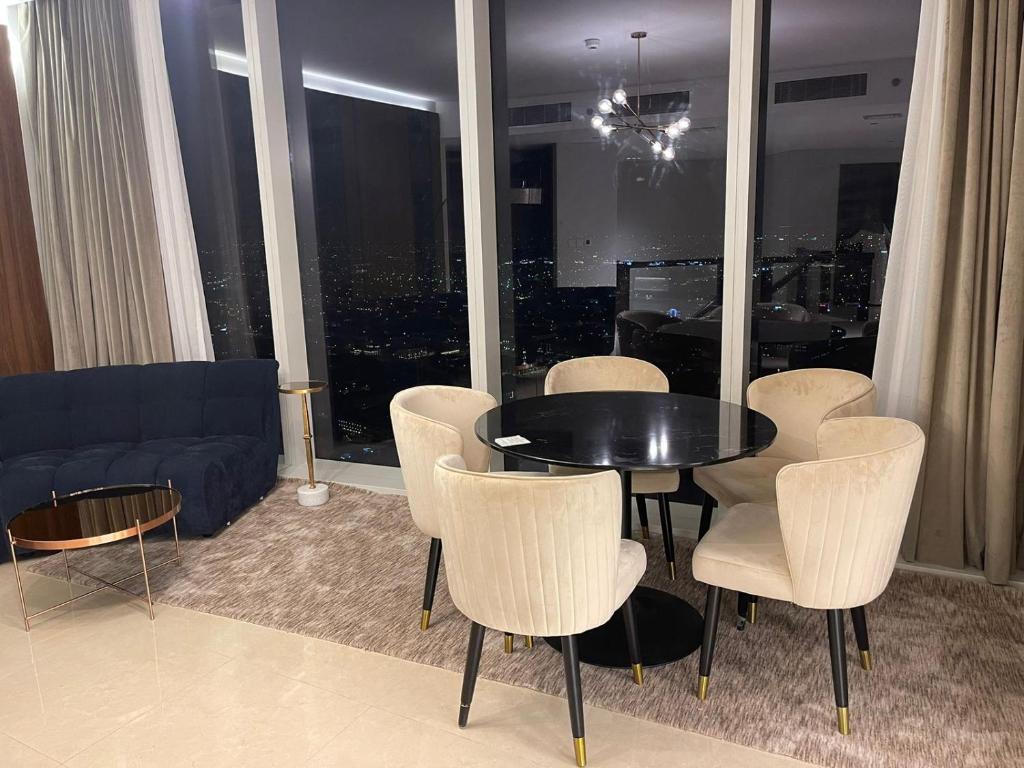 利雅德Raffal Tower Apartment的客厅配有桌椅和沙发
