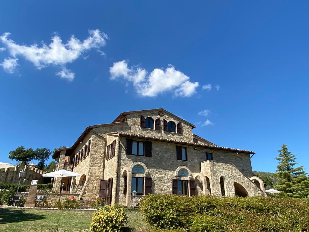 贝瓦尼亚Antico Borgo Carceri & Wellness的一座蓝色天空的大石头建筑
