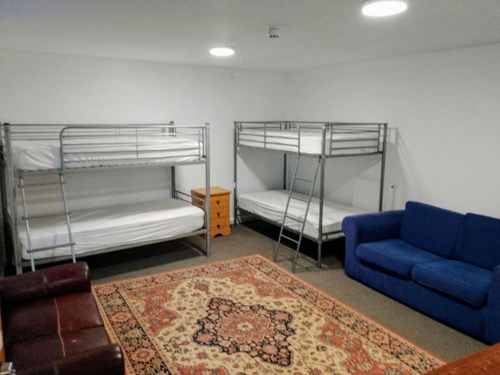 廷塔杰尔Dolphins Backpackers的客厅配有两张双层床和蓝色沙发
