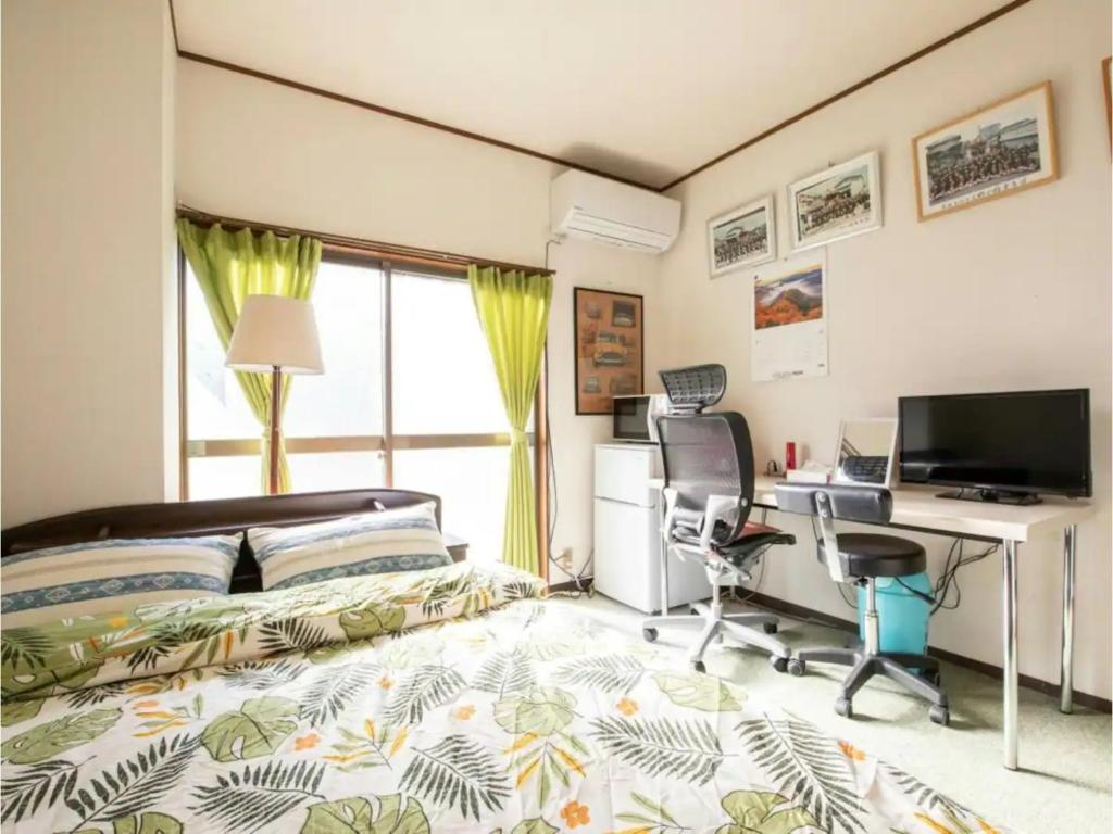 泉大津市Minpaku Yamamoto - Vacation STAY 13869的一间卧室配有一张床、一张桌子和一台电脑