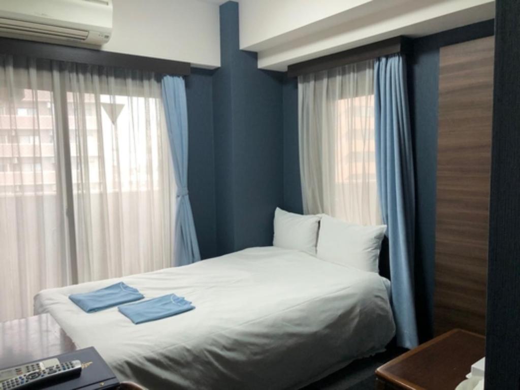 东京Hotel Business Villa Omori - Vacation STAY 08202v的一间卧室配有一张带2条蓝色毛巾的床