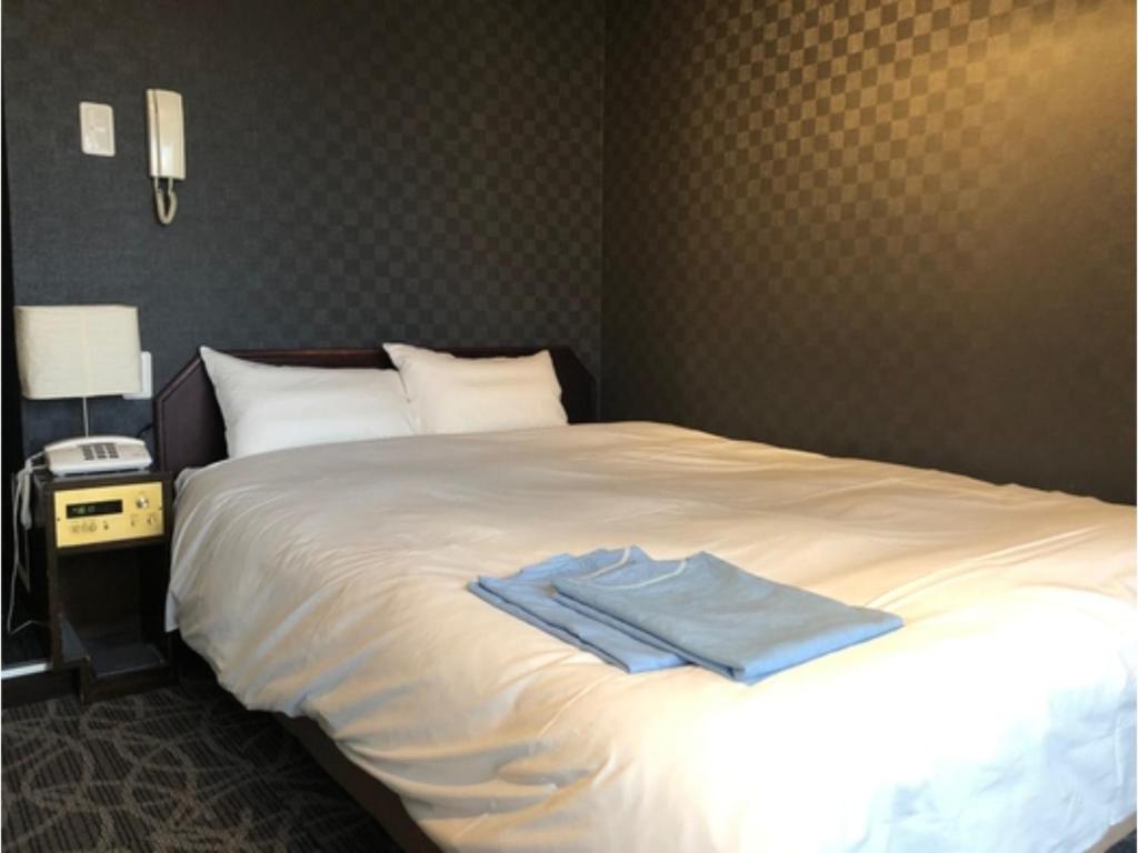 东京Hotel Business Villa Omori - Vacation STAY 08209v的一间卧室,床上有蓝色衬衫