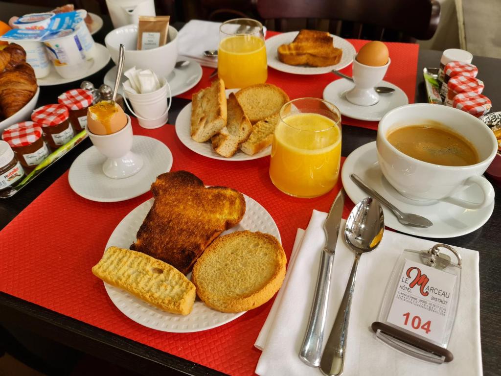 里摩日Hôtel Bistrot Le Marceau的餐桌,早餐包括烤面包、咖啡和橙汁