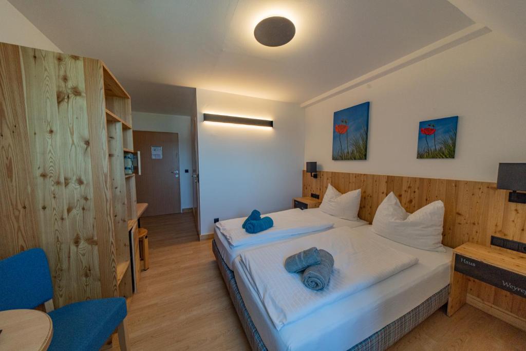 魏勒格Haus Weyregg - Pension的一间卧室配有一张带2条蓝色毛巾的床
