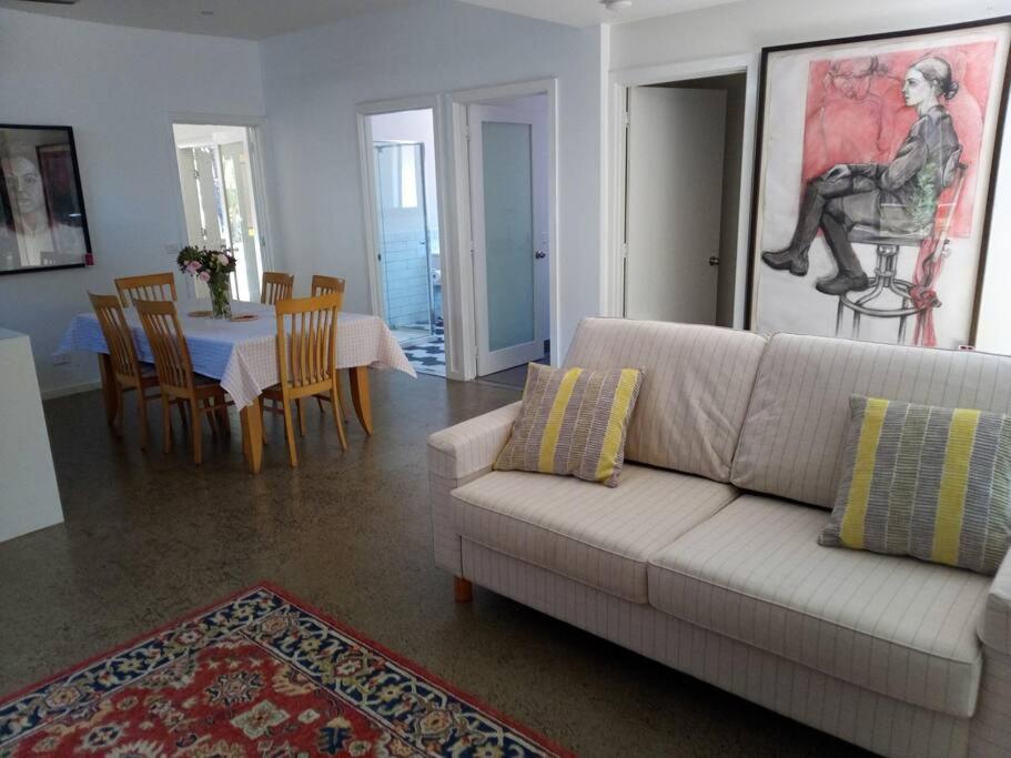 本迪戈The Artist's Cottage的客厅配有白色的沙发和桌椅