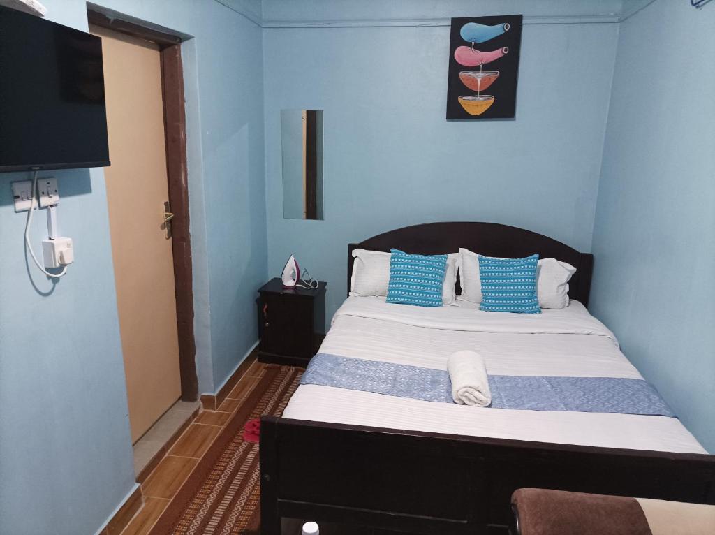 奈瓦沙Devine Studio in Naivasha Town的一间卧室配有一张带蓝色墙壁的大床