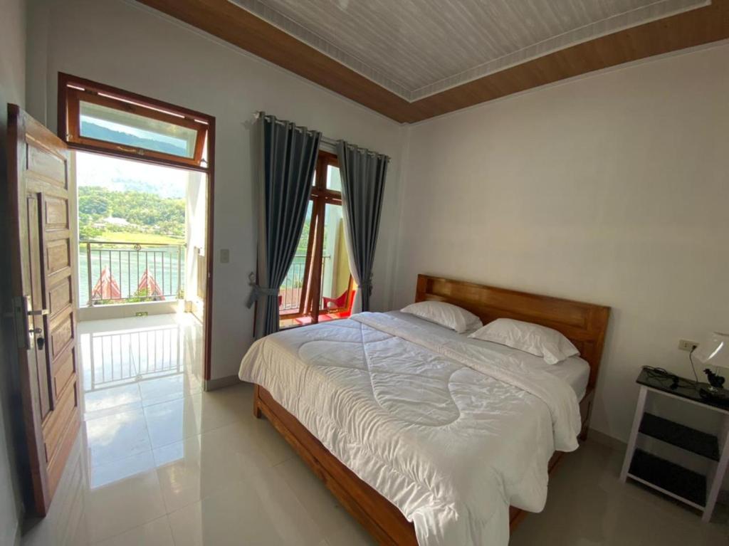 图克图克Tama View的一间卧室设有一张床和一个窗口