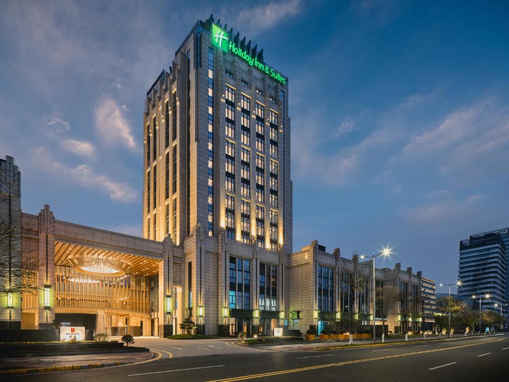 昆山Holiday Inn & Suites Kunshan Huaqiao, an IHG Hotel - F1 Racing Preferred Hotel的上面有绿色标志的高楼