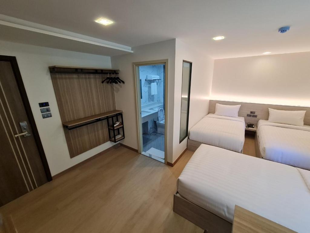 曼谷Thana Wisut Hotel - SHA Plus的酒店客房设有两张床和一个阳台。