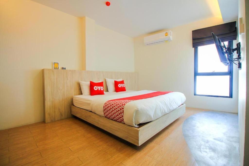 曼谷OYO 75416 Rama3 Sunrise Hostel的一间卧室配有一张带红色枕头的床