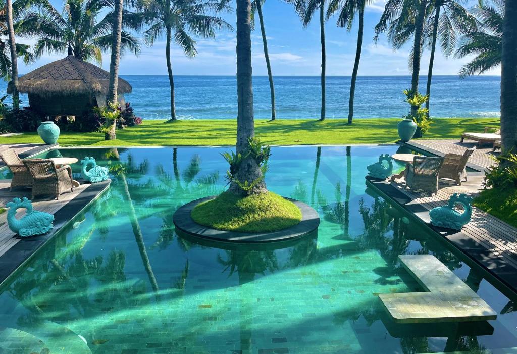 提安亚尔Louka Beach Bali的一座背景海洋的游泳池