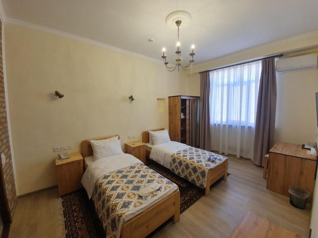 塔什干Chorsu Inn的酒店客房设有两张床和吊灯。