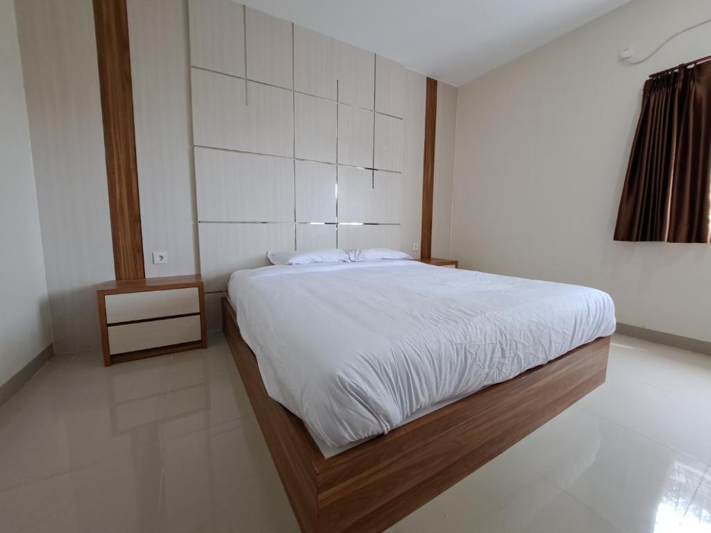 巴厘巴板Pillow Guest House的一间卧室配有一张带白色床单的大床