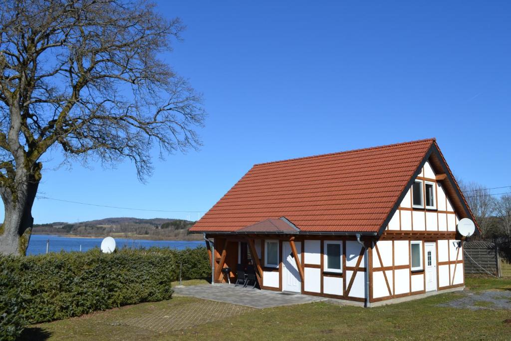 DriedorfHM - Ferienhaus 2 Deluxe Krombachtalsperre Westerwald exklusive verbrauchte NK的一座红色屋顶的房子和一棵树