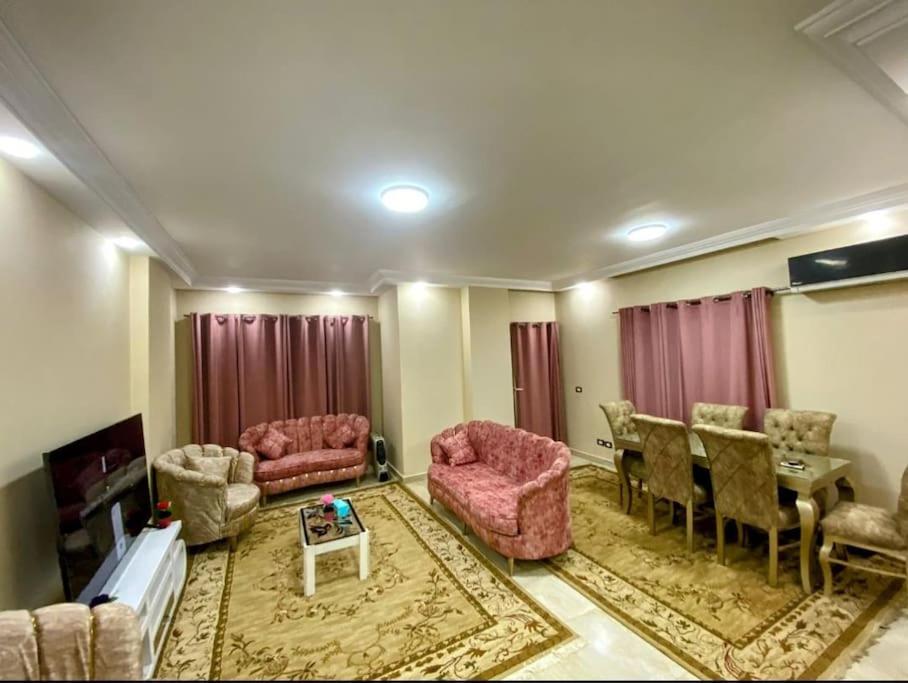 开罗Dreams House in Maadi的客厅配有粉色家具和桌子