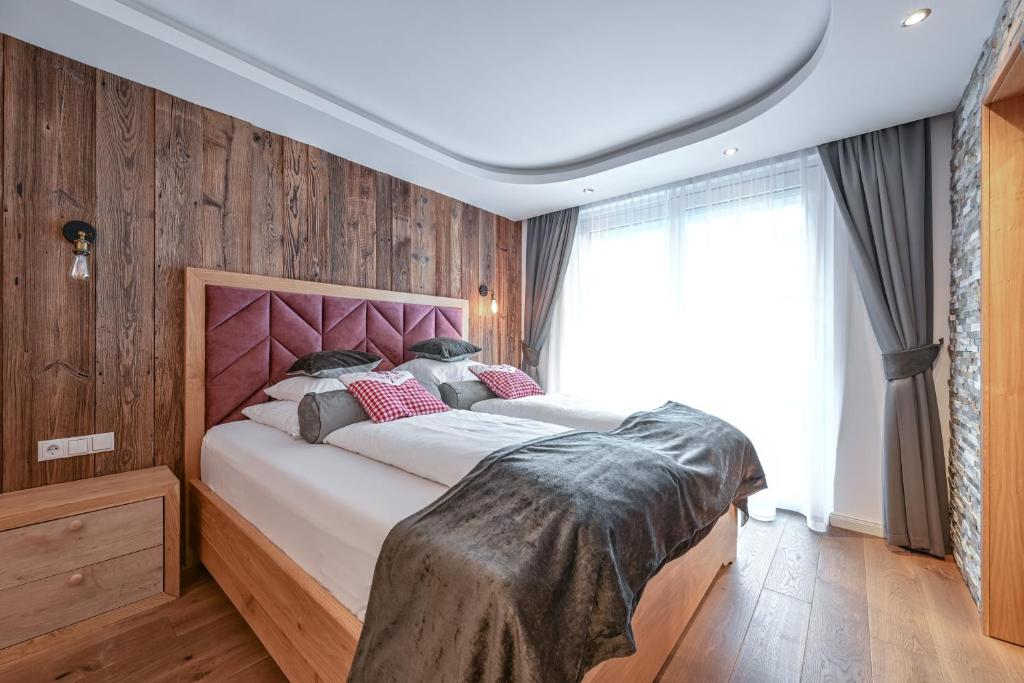 厄茨阿姆巴赫别墅旅馆的一间卧室配有一张带粉红色床头板的大床