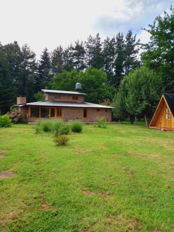 埃尔奥约Hostel Chacra La Templanza的草地庭院中的房屋