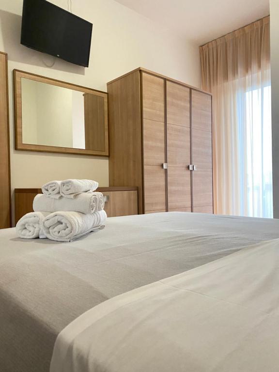 里米尼Hotel Ravello da Lorenzo e Moira Adults only的一间卧室配有带3条毛巾的床
