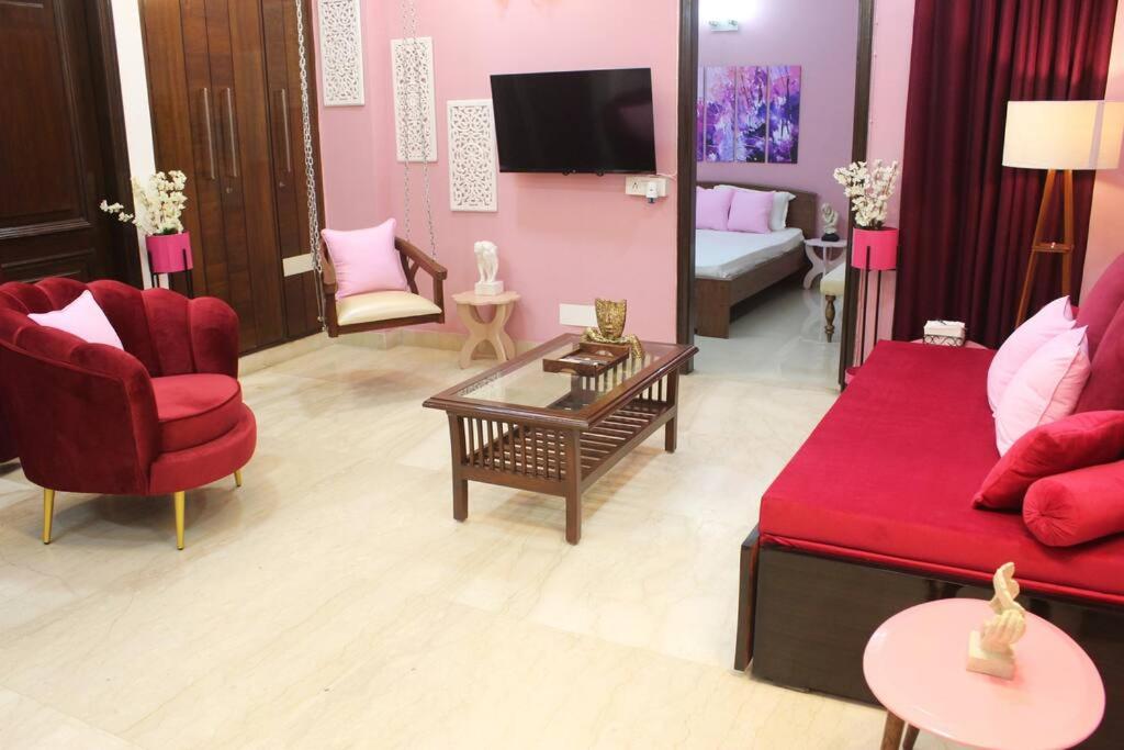 新德里Luxurious modern 2BHK prime location Delhi (13)的客厅配有红色沙发和红色椅子