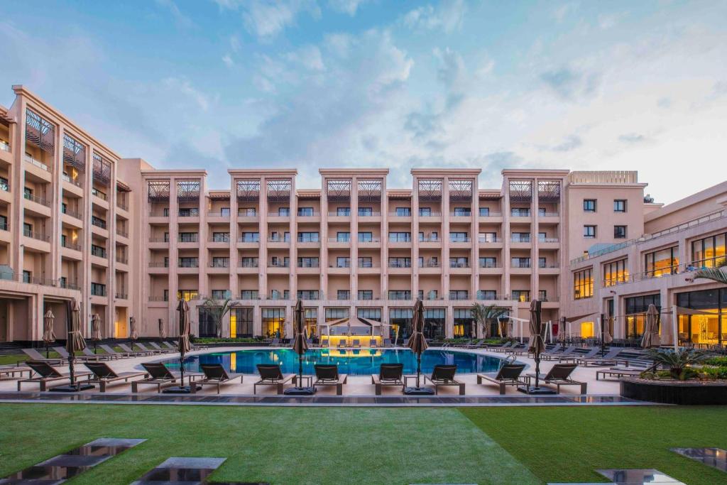 开罗Triumph Luxury Hotel的享有带游泳池的大型建筑的外部景色