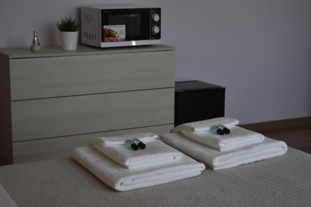 罗镇Villa Giulini Rho的两套毛巾,放在床上,配有微波炉