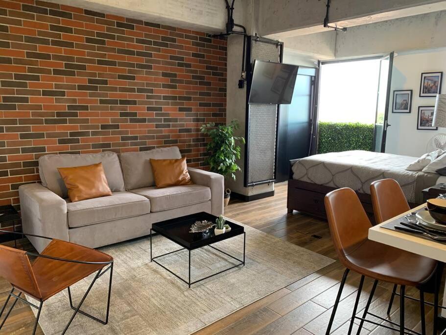 危地马拉Apartamento de lujo, MODERNO estilo NEW YORK的带沙发和砖墙的客厅
