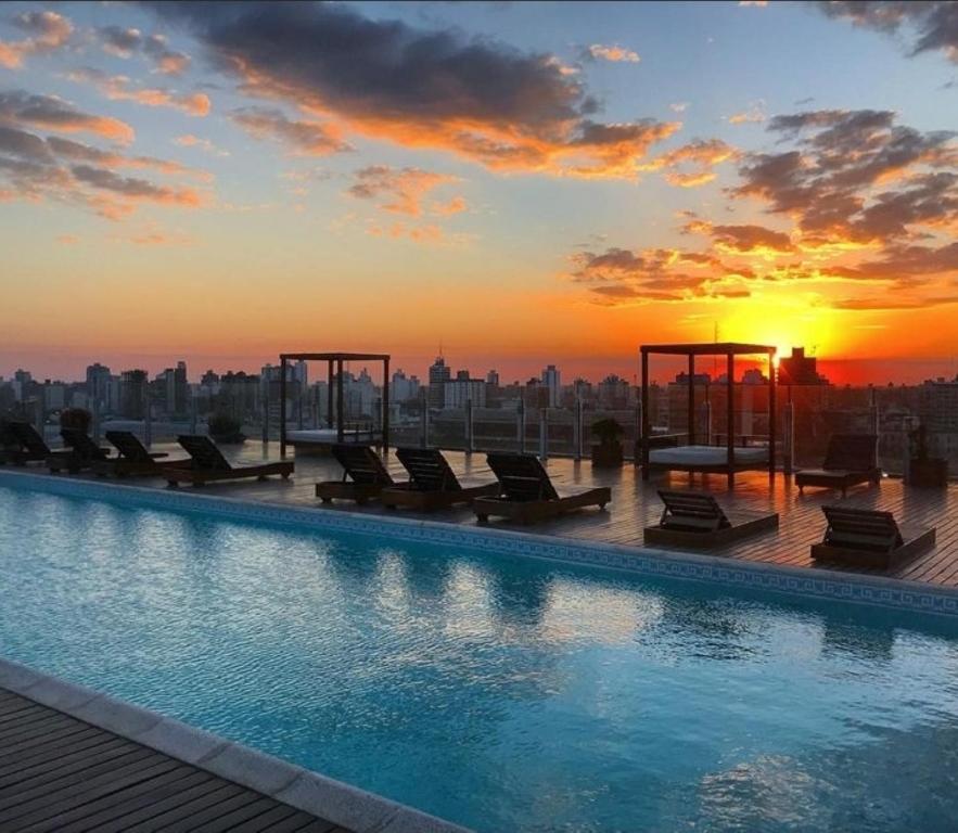 圣达菲洛斯西洛斯酒店的一座享有日落美景的建筑屋顶上的游泳池