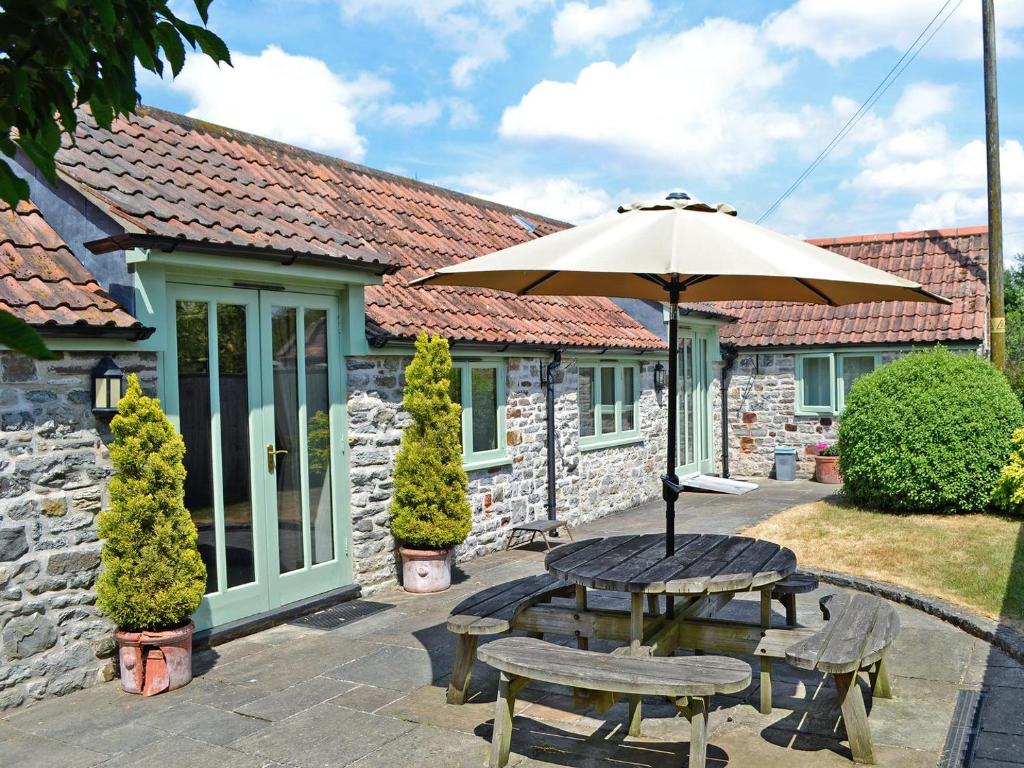 奇平索德伯里Bluebell Cottage - E4741的庭院配有遮阳伞和桌椅。
