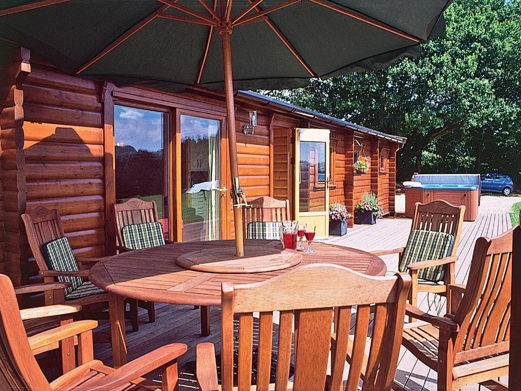 廷特恩Cider Mill Lodge - Hw7420的甲板上配有一张木桌和椅子及遮阳伞