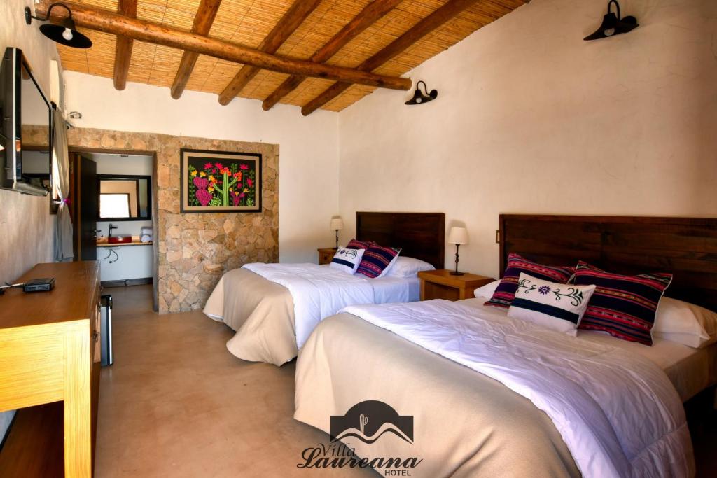胡阿卡勒拉Villa Laureana的一间卧室设有两张床和石墙