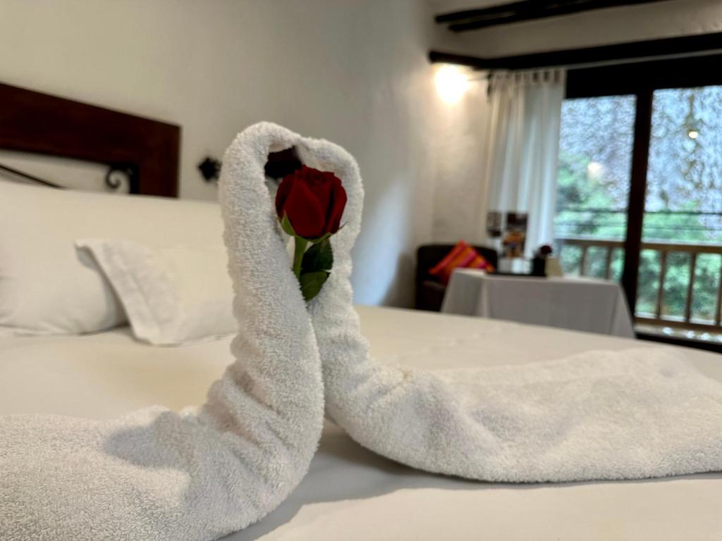 马丘比丘Hatun Inti Boutique的一只毛巾动物,形状像玫瑰,坐在床上