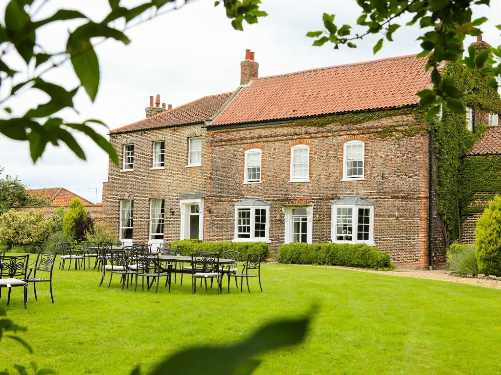 约克Manor House的一座大砖砌建筑,庭院里设有桌椅