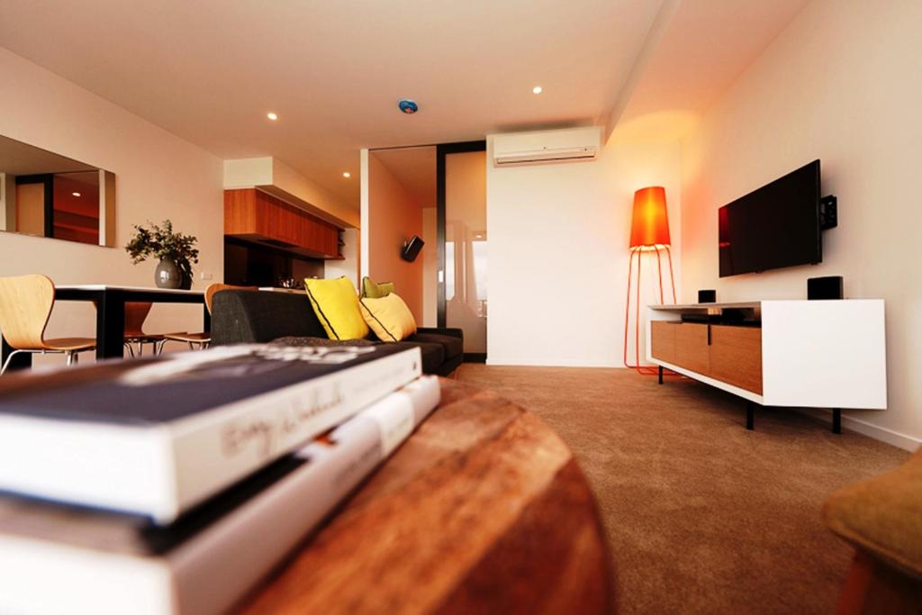 布里斯班Vine Apartments South Brisbane的客厅配有沙发和带电视的桌子