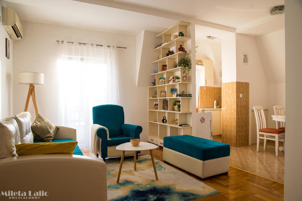 波德戈里察Sunny 412 apartment的客厅配有沙发、椅子和桌子