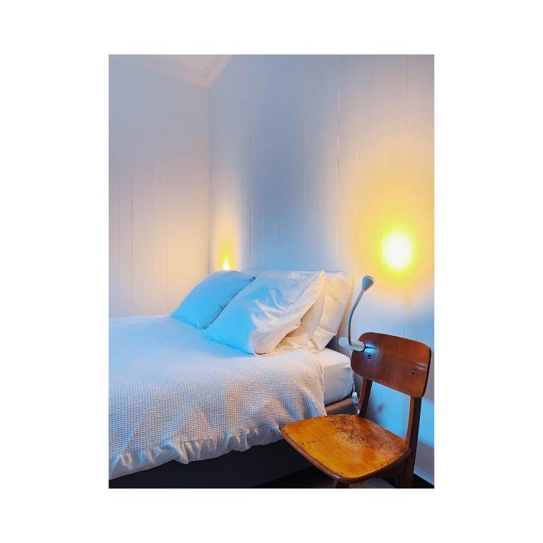 Lo-ReningeIn nduuk的卧室配有白色的床和木椅