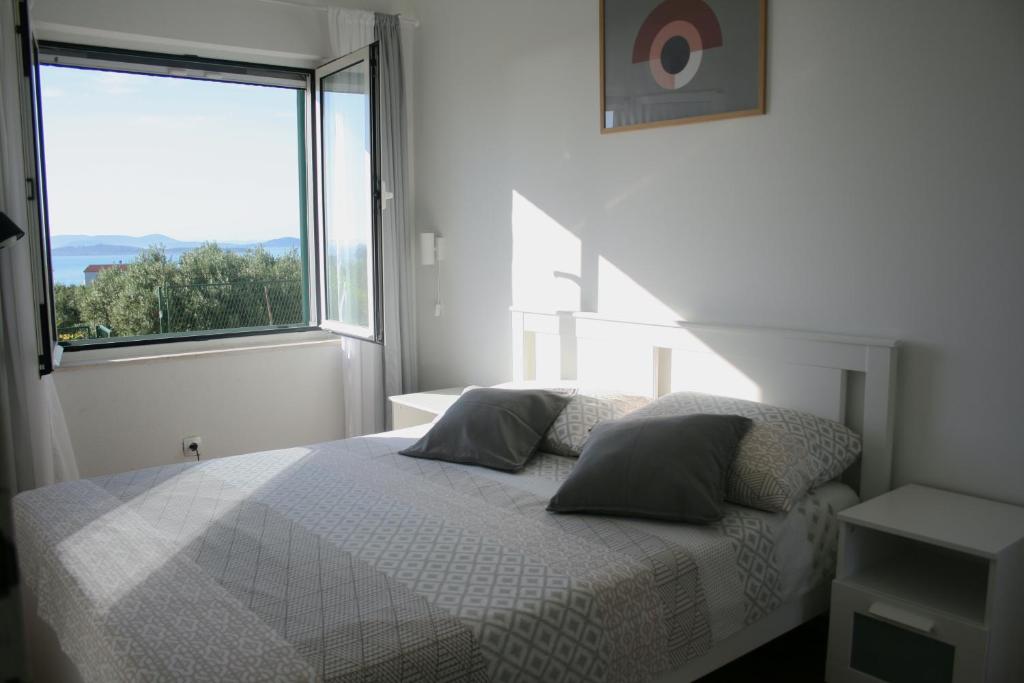 普利莫顿Apartman Ita的白色的卧室设有床和大窗户