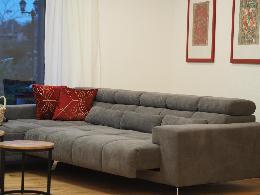 梅尔齐希foxxbau - urlaubswohnen im Saarschleifenland的客厅配有一张灰色沙发,配有一张桌子