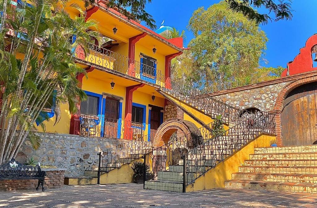 埃斯孔迪多港Hotel Rancho Escondito的前面有楼梯的黄色建筑