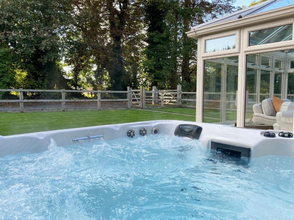 BlankneyRectory Cottage的后院的热水浴池,设有玻璃屋